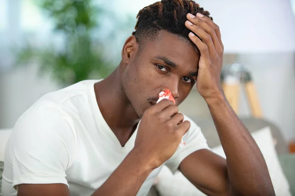stock image young man touching his bleeding nose