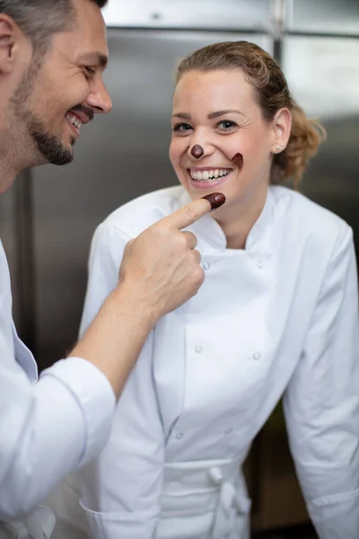 Chef Playfully Putting Chocolate Her Colleagues Face — Stock Photo, Image
