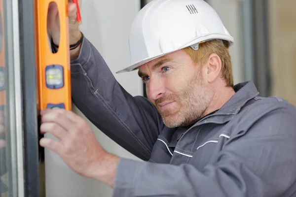 builder checking work done with a spirit level