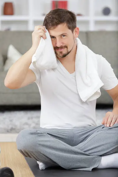 man with towel at home after doing exercise