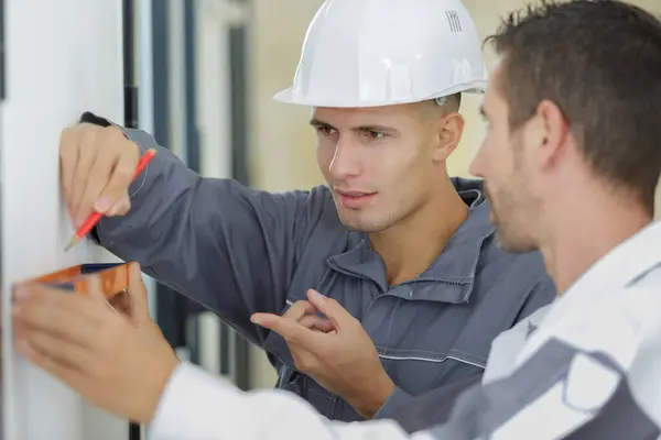 Builder Apprentice Inspecting Level — Stock Photo, Image