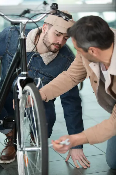 Two Men Adjusting Bicycle Wheel — Stock Photo, Image