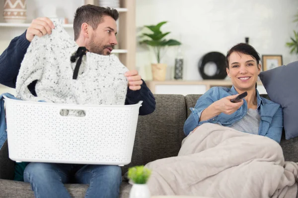Mann Mit Wäschekorb Schaut Frau Beim Fernsehen — Stockfoto
