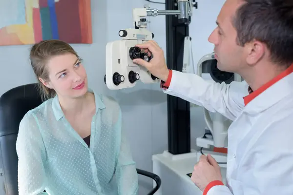 診療所の若い女性と話す眼科医 — ストック写真