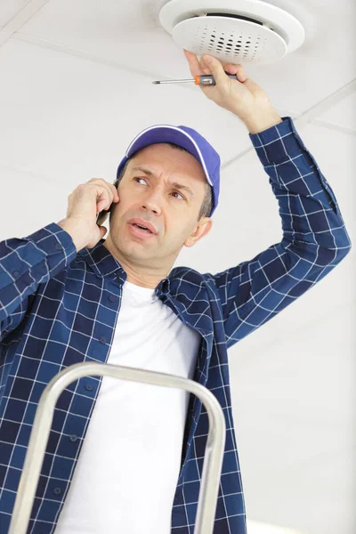 Construction Worker Phone Fixing Ceiling Issue — Stock Photo, Image