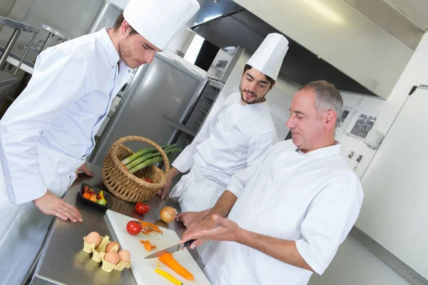 apprentices cooks learning with experienced chef