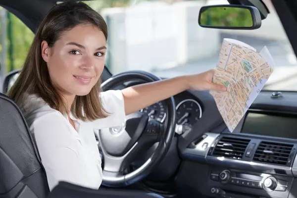 a woman in a car with a map of roads