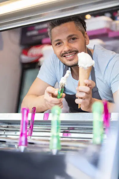 ハンサムな男が笑顔でアイスクリームを提供する — ストック写真