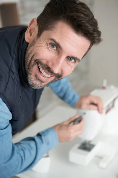 man fixing a sewing machine