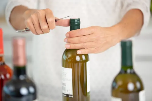 Eine Frau Öffnet Eine Flasche Wein Mit Einem Korkenzieher — Stockfoto