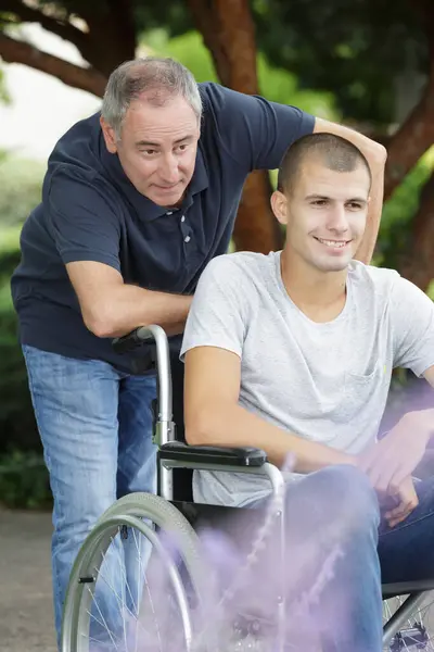 Tekerlekli Sandalyedeki Genç Engelli Erkek Bakıcı — Stok fotoğraf