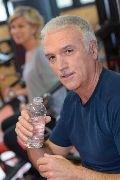 senior man in fitness drinking water