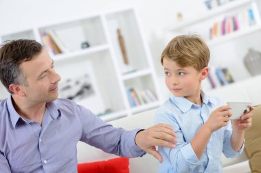 Man touching arm of child holding cellphone clipart