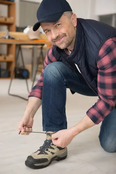 Smiling Workman Tying His Bootlaces — Stock Photo, Image