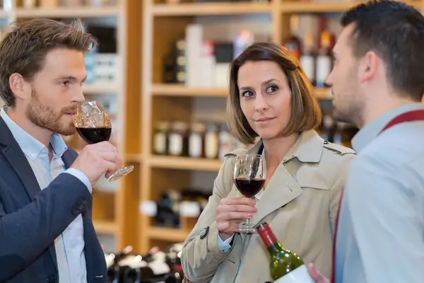 couple during a wine tasting with sommelier assisting them