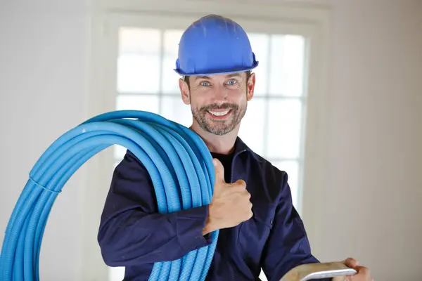 Sorrindo Construtor Dentro Casa Segurando Tubos — Fotografia de Stock