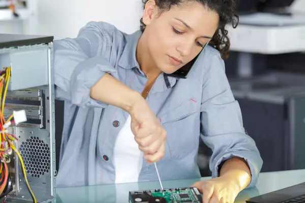 女性の労働者がコンピュータのピースをねじる — ストック写真