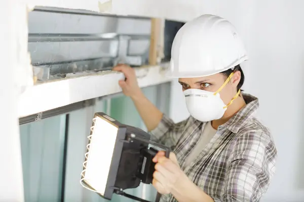 Arbeiterin Mit Maske Beleuchtet Arbeitsbereich Mit Scheinwerfer — Stockfoto