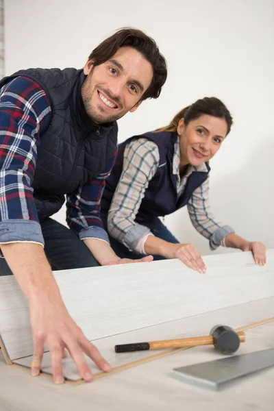woman and man installing wood floor