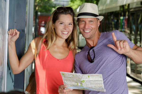 tourist couple holding map smiling