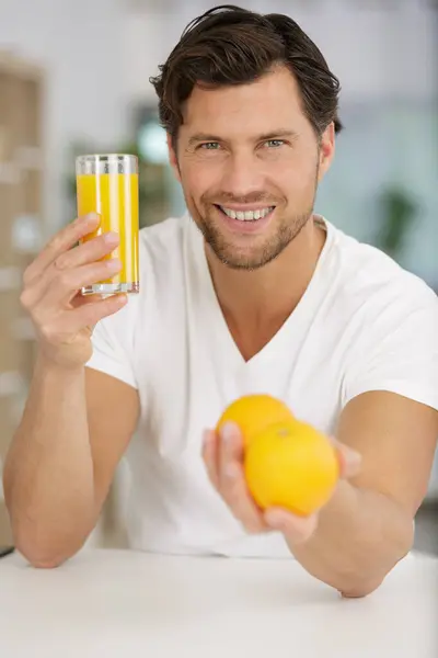 man holding orange juice and fruits