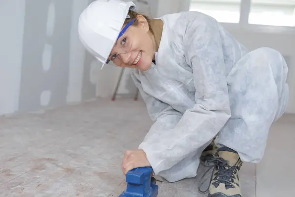 Happy Female Contractor Sanding Wooden Floor Workshop — Stock Photo, Image