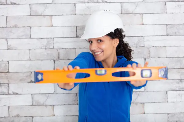female builder holding level tool