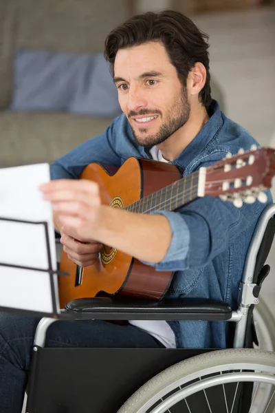 a happy disable man playing guitar