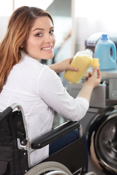 happy disable woman doing a washing machine