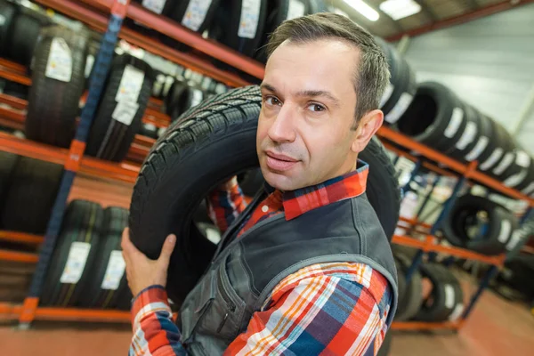 Mechaniker Trägt Einen Reifen Einer Garage — Stockfoto