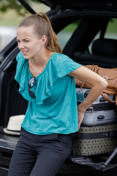Młoda Dama Próbuje Wcisnąć Swój Bagaż Samochodu — Zdjęcie stockowe