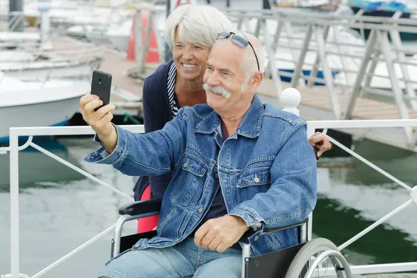 a senior couple in wheelchair doing a selfie
