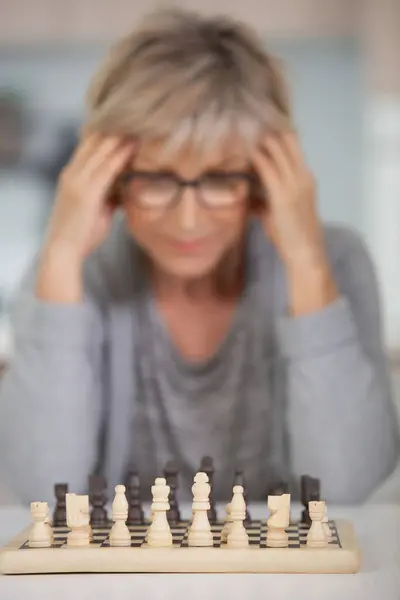 a senior woman playing chess