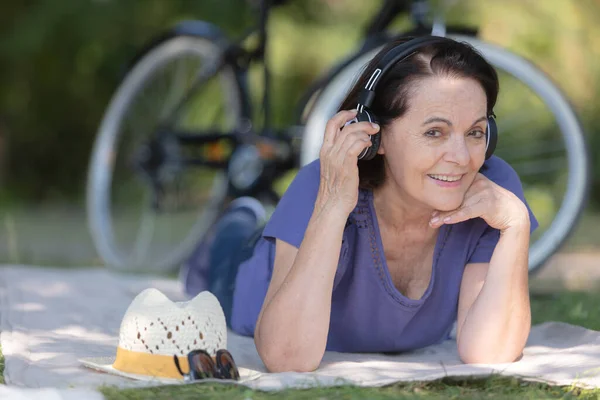 senior woman in fitness outfit relaxing in park