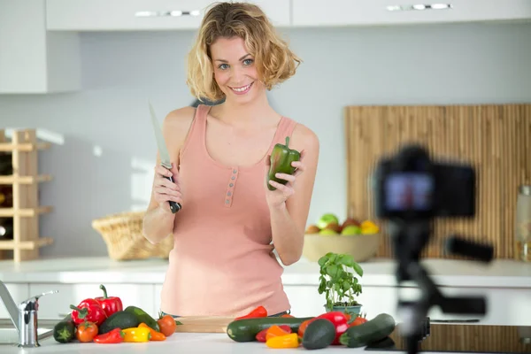 woman with raw vegetables recording a cookery blog