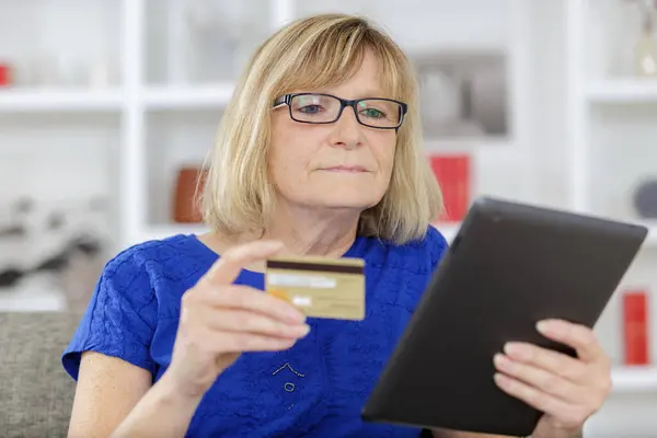 高级妇女在平板电脑上提供信用卡 — 图库照片