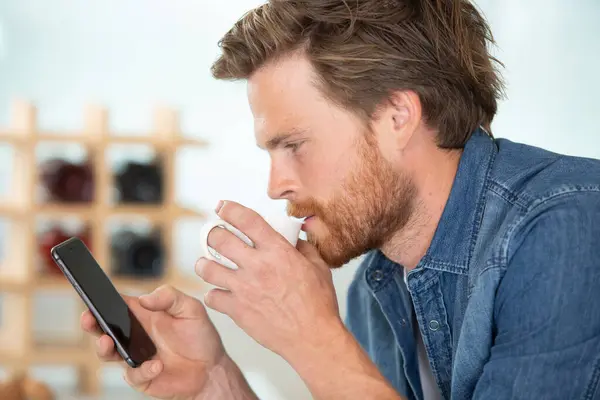 Άνθρωπος Κοιτάζοντας Smartphone Και Πίνοντας Έναν Καφέ — Φωτογραφία Αρχείου