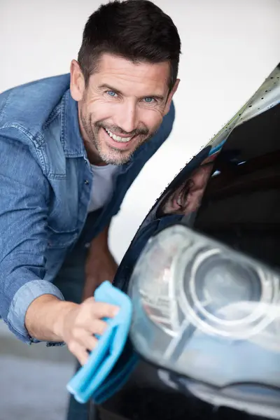 a man cleaning car with cloth