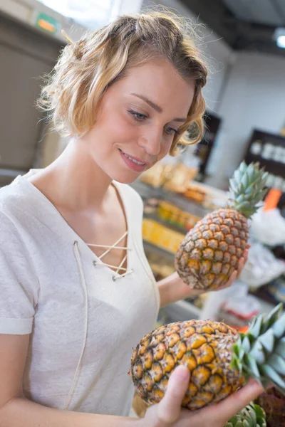 女人在超市挑选水果 拿着菠萝 — 图库照片