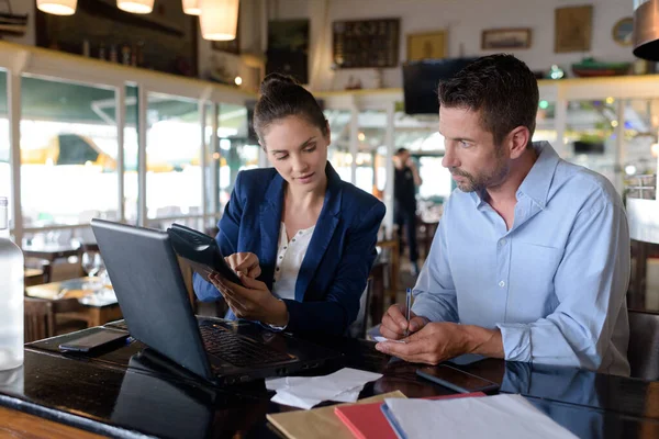man and woman discussing business issues with laptop