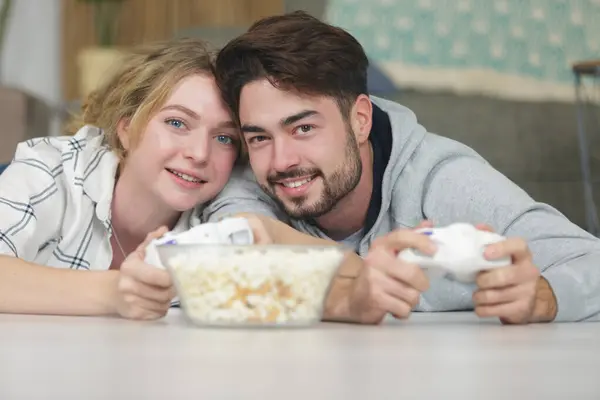 sweet couple playing video game popcorn at front