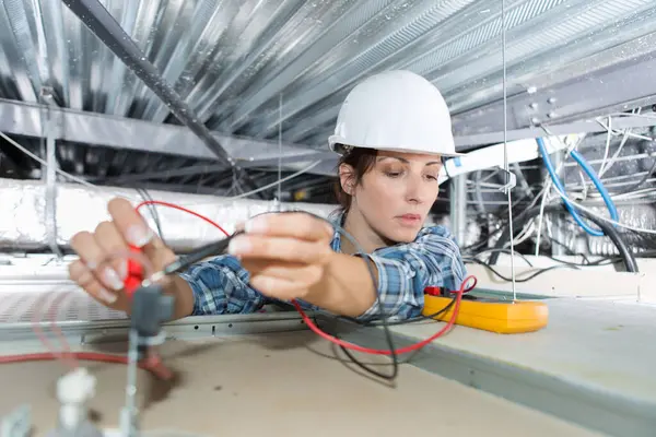 Vrouwelijke Elektricien Met Behulp Van Multimeter Schijnwerpers Testen — Stockfoto