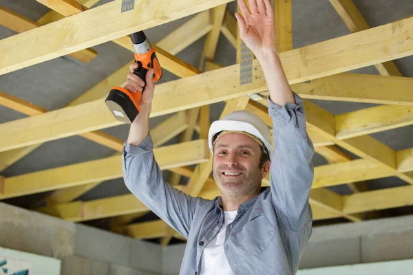 Bauarbeiter Mit Akkubohrmaschine Auf Dachbalken — Stockfoto
