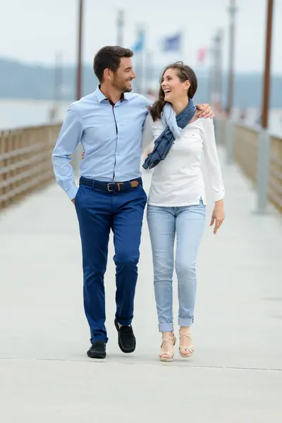 young couple walking on pier
