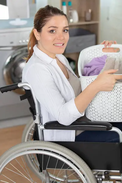 woman in a wheelchair doing laundry