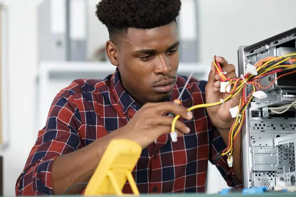 male technician rewiring a computer