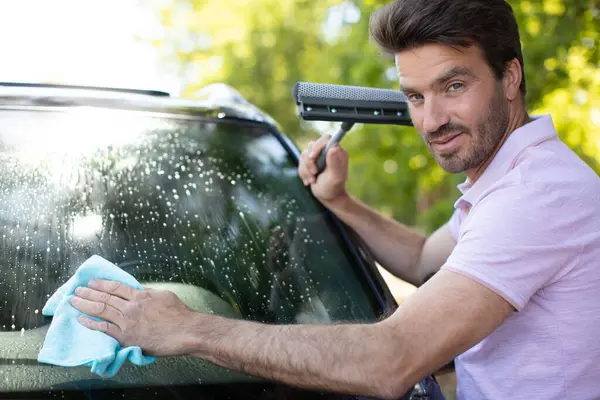 布で車のフロントガラスを掃除する男 — ストック写真