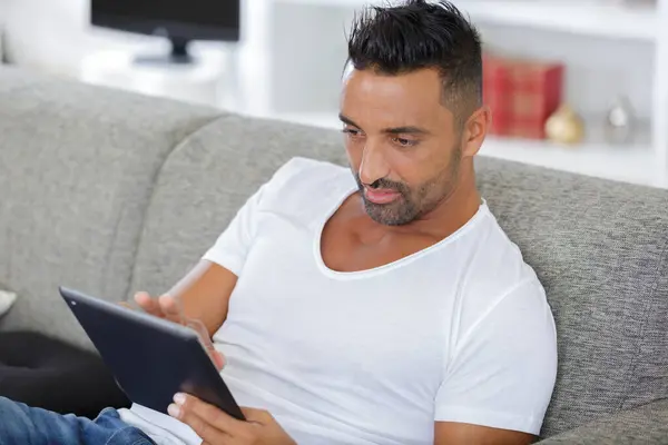 jolly bearded guy having rest using computer gadget indoors