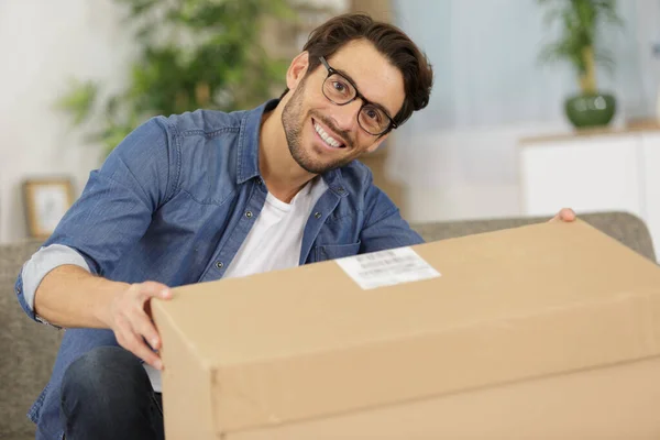 smiling man with cardboard boxes at home