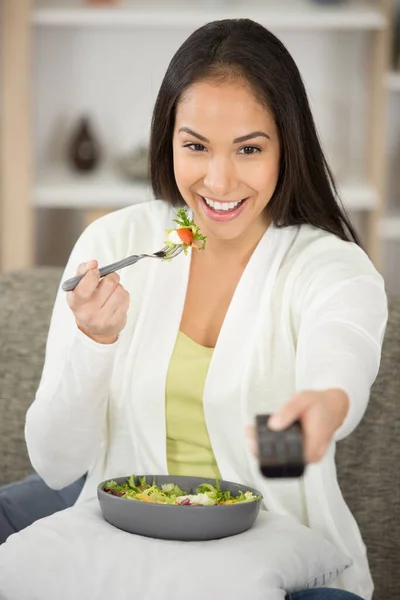 Młoda Szczęśliwa Zdrowa Kobieta Jedząc Sałatkę Podczas Oglądania Telewizji — Zdjęcie stockowe